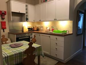 a kitchen with a table with a green bowl on the counter at Glastonbury Rose Cottage in Glastonbury