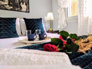 a room with a bed with a table with two cups and roses at Gloria Apartment in Zakynthos Town