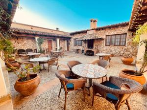patio ze stołami i krzesłami oraz kamienny budynek w obiekcie Agroturismo Ses Illes w mieście Costitx