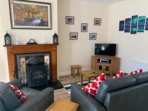 a living room with two couches and a fireplace at Mayfield House Holiday home in Ballinrobe