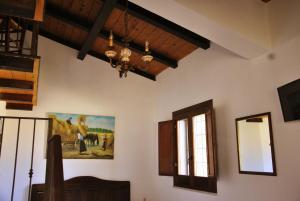 uma sala de jantar com um lustre e uma pintura na parede em Agriturismo La Mandragola Relais em Crotone