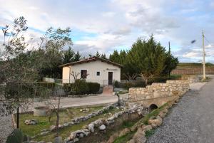 uma pequena casa com uma parede de pedra ao lado de uma estrada em Agriturismo La Mandragola Relais em Crotone