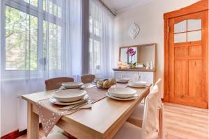 a dining room with a wooden table and chairs at Victus Apartamenty, Apartament Sztokholm in Sopot