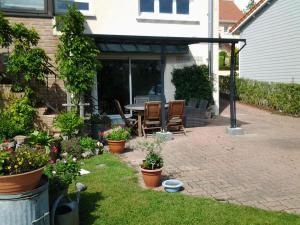 a patio with a table and chairs and plants at Chambres d’hotes vue sur la Campagne in Marquise