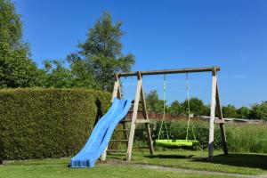 a playground with a blue slide and a green swing at Ferienwohnung Christophers in Stedesdorf
