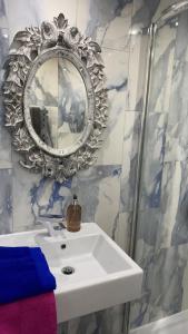 a bathroom with a white sink and a mirror at The Coquet Apartment - short stroll to Warkworth Castle and Hermitage in Warkworth