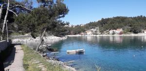 a small boat in the water next to a sidewalk at Vivi studio apartments in Mali Lošinj