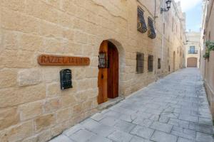 un callejón con una señal en el lateral de un edificio en Ta' Frenc Farmhouse, en Għarb