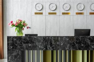 a vase of flowers on a counter with clocks on the wall at Riverwood Relax Park in Moshny