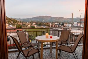 un tavolo e sedie su un balcone con vista di Sofias Studios East Home a Néos Marmarás