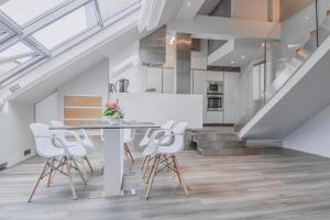 ein Wohnzimmer mit einem Tisch, Stühlen und einer Treppe in der Unterkunft Luxury Apartment in Centre in Prag