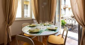 a white table with chairs and wine glasses on a balcony at Casa di Jo in Como