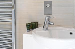 een badkamer met een witte wastafel en een douche bij Red Lion Court by City2Stay in Londen +38 foto's