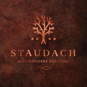 a logo with a tree on a brown background at STAUDACH - Alpinresidenz Zillertal in Ramsau im Zillertal