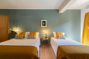 2 Betten nebeneinander in einem Zimmer in der Unterkunft Hotel Carvalho Araujo in Geres