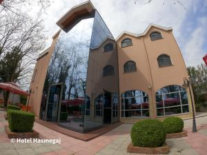 un edificio con una gran ventana de cristal en una calle en Hotel Hasmegaj en Mjedë