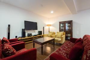 a living room with red furniture and a flat screen tv at Hotel Carvalho Araujo in Geres