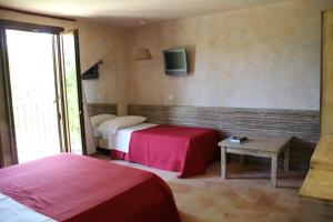 pokój hotelowy z dwoma łóżkami i telewizorem w obiekcie Tenuta Conte Ruggero w mieście Santa Domenica