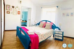 um quarto com uma cama azul com um cobertor vermelho e branco em Casa Alfazema do Monte em Santa Marta