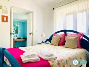 sypialnia z dużym łóżkiem z ręcznikami w obiekcie Casa Alfazema do Monte w mieście Santa Marta