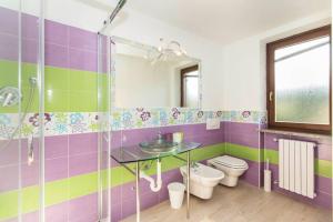 een paarse en groene badkamer met een wastafel en een toilet bij Casa Angeletti in Gassino Torinese