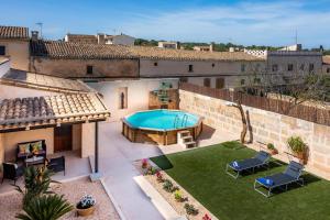 an outdoor patio with a pool and a yard at Cas Padri Pep in Ariany