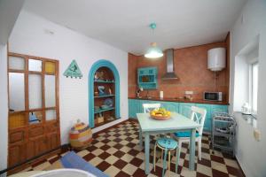 una cocina con una mesa con un bol de fruta. en DUPLEX TARIFEÑO in the OLD TOWN, en Tarifa