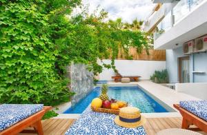 una piscina con fruta en una mesa junto a una casa en Enorme Serenity Spritz - Adults Only en Hersonissos
