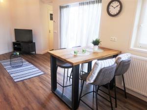 a dining room table with chairs and a clock on the wall at DWC00 - New romantic studio with large terrace in Domburg