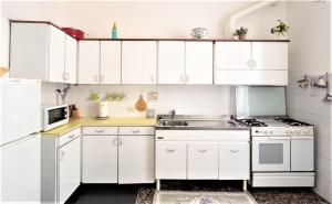 a kitchen with white cabinets and a sink at Mysa Properties Appartamento Genova in Genova