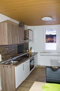 Haus am Kroatenbach في Lautenthal: مطبخ فيه دواليب بيضاء وسقف اصفر