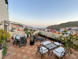 een patio met tafels en stoelen op een dak bij Holiday House Penthouse in La Gomera in San Sebastián de la Gomera