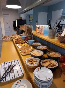 un buffet con platos y tazones de comida en una mesa en Kyriad Direct Saintes, en Saintes