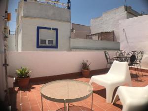 a patio with a table and chairs on a balcony at DUPLEX TARIFEÑO in the OLD TOWN in Tarifa