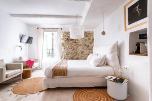 Habitación blanca con cama y sofá en DODO etc - La Bastide du Vieux Chêne - TERITORIA en Condorcet