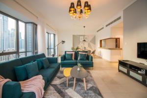 a living room with blue couches and a tv at Luxury 2BR facing Burj Khalifa! - south ridge in Dubai
