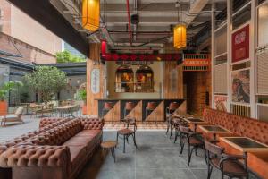 a restaurant with leather couches and tables and a bar at Masaya Medellin in Medellín