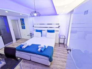 um quarto com uma grande cama branca com lençóis azuis em Mariandry Apartments em Lárnaca