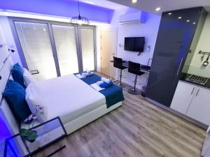 a bedroom with a large white bed and a kitchen at Mariandry Apartments in Larnaka