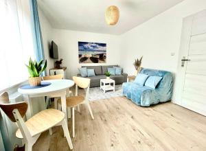 a living room with a table and a couch at Willa RAFA in Jastarnia