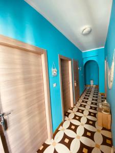 un pasillo con paredes azules y suelo de baldosa en Villa Del Mare, en Campomarino