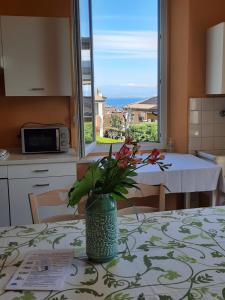 a vase with flowers on a table in a kitchen at Appartamenti Esmera in Desenzano del Garda