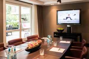 a dining room with a table and a television at Boston Hotel HH in Hamburg