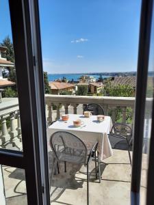 a table on a balcony with a view of the ocean at Appartamenti Esmera in Desenzano del Garda
