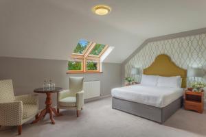 a bedroom with a bed and a table and chairs at The Malone Hotel in Belfast