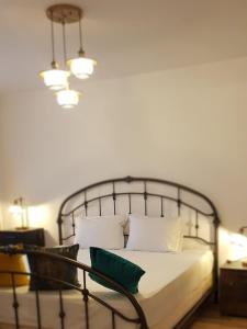 布拉索夫的住宿－SAVAS CLASIC BRASOV，一间卧室配有一张带金属框架和枕头的床