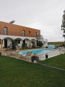 a house with a swimming pool in front of it at Casa das Portas in Azinhaga