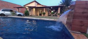 a pool with a waterfall in front of a house at Vivenda Malu in Luis Correia