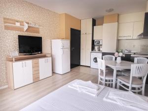 a living room with a kitchen and a table with chairs at Aпартаменти Хоризонт in Sozopol