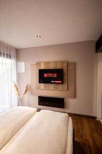 1 dormitorio con 1 cama y TV en la pared en 24Seven Hotel Schwabach en Schwabach